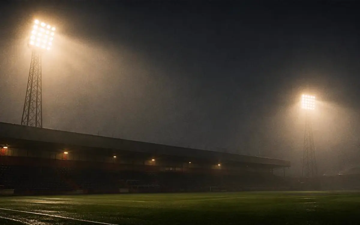 Reflectores de estadio atravesando la niebla nocturna