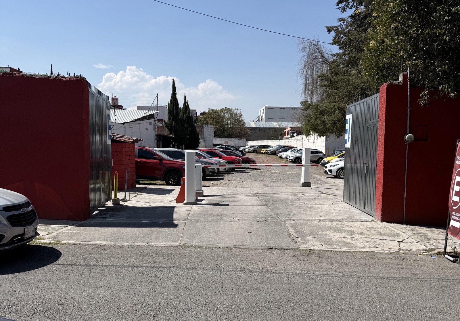 Acceso principal de Glez & Pichardo Boulevard, con pluma automática y señalética E de estacionamiento